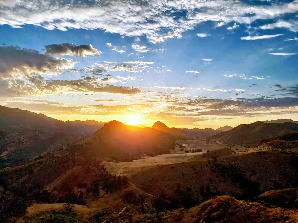 Golden Horizon: A Majestic Sunset Over Mountain Peaks and Serene Skies