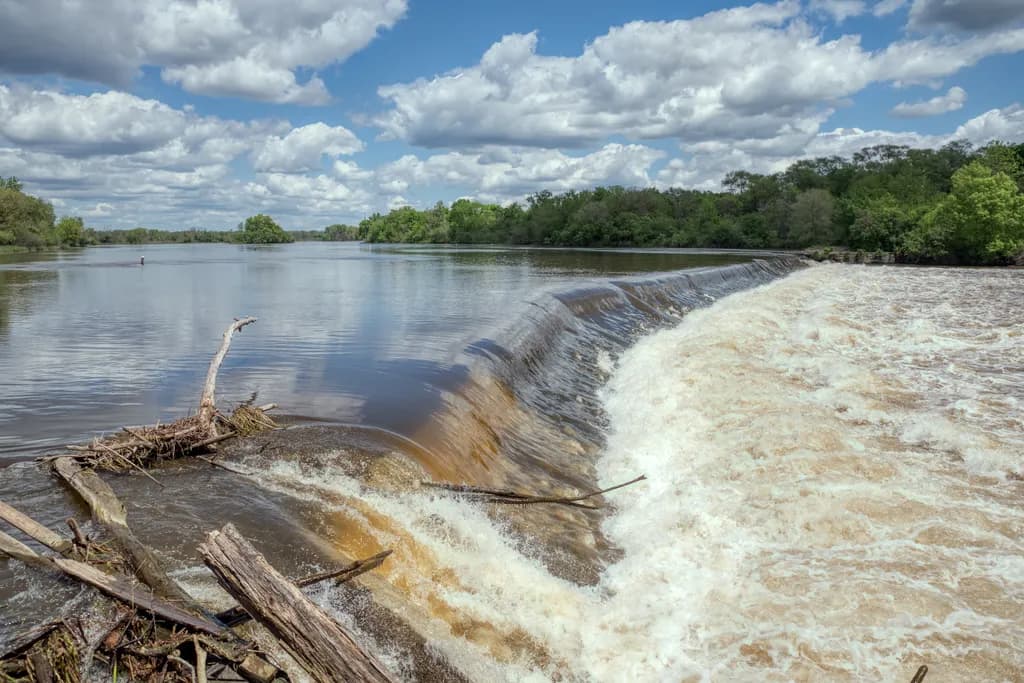 Tranquil Waters: A Serene Landscape of River and Waterfall Under Cloudy Skies