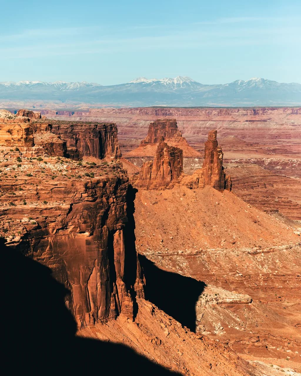 Majestic Echoes of the Canyon: A Serene Landscape of Red Rock Formations and Snow-Capped Peaks
