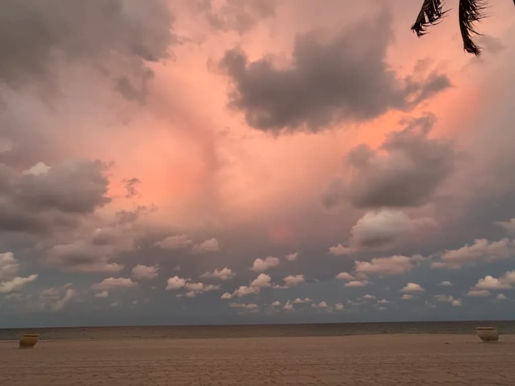Serenity at Dusk: A Tranquil Beach Sunset with Dreamy Clouds