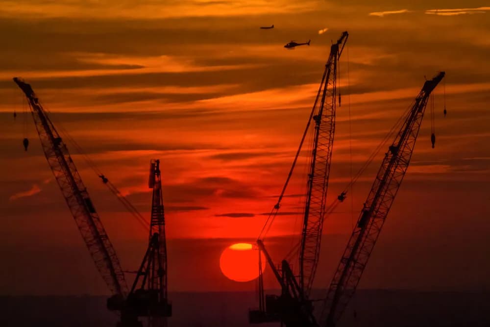 Cranes at Dusk: A Sunset Symphony of Construction and Sky