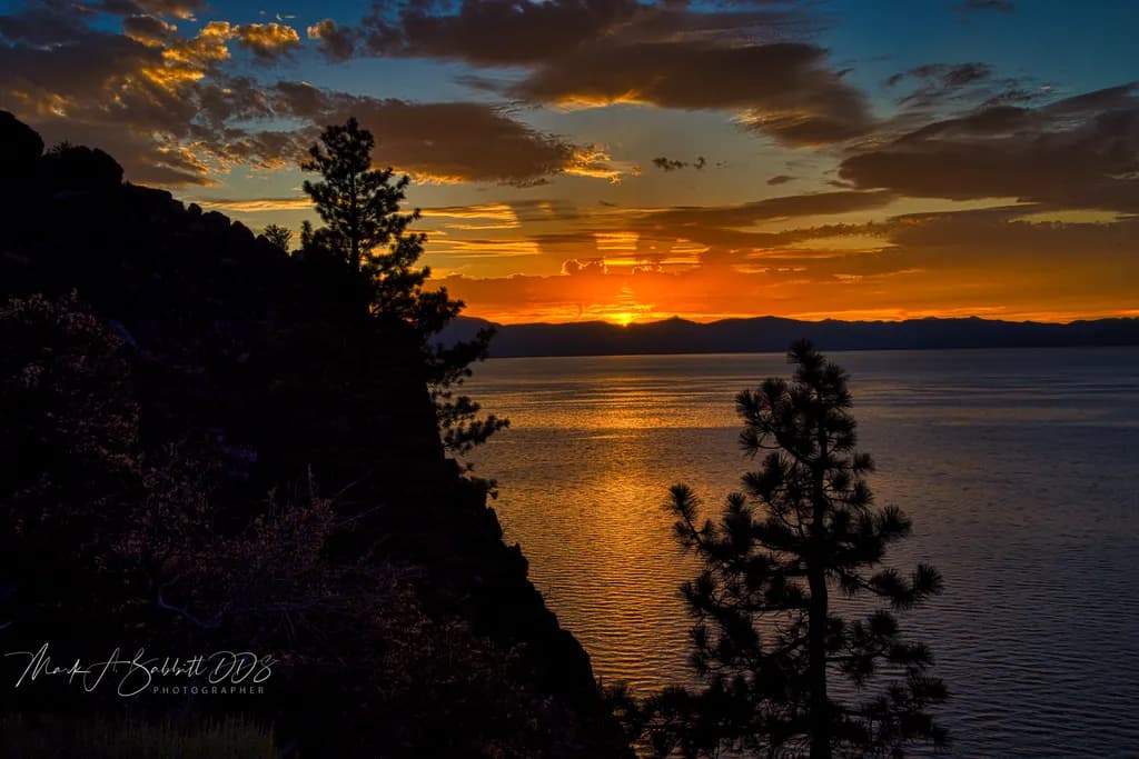 Serenity at Dusk: A Tranquil Sunset Reflection Over Water and Trees