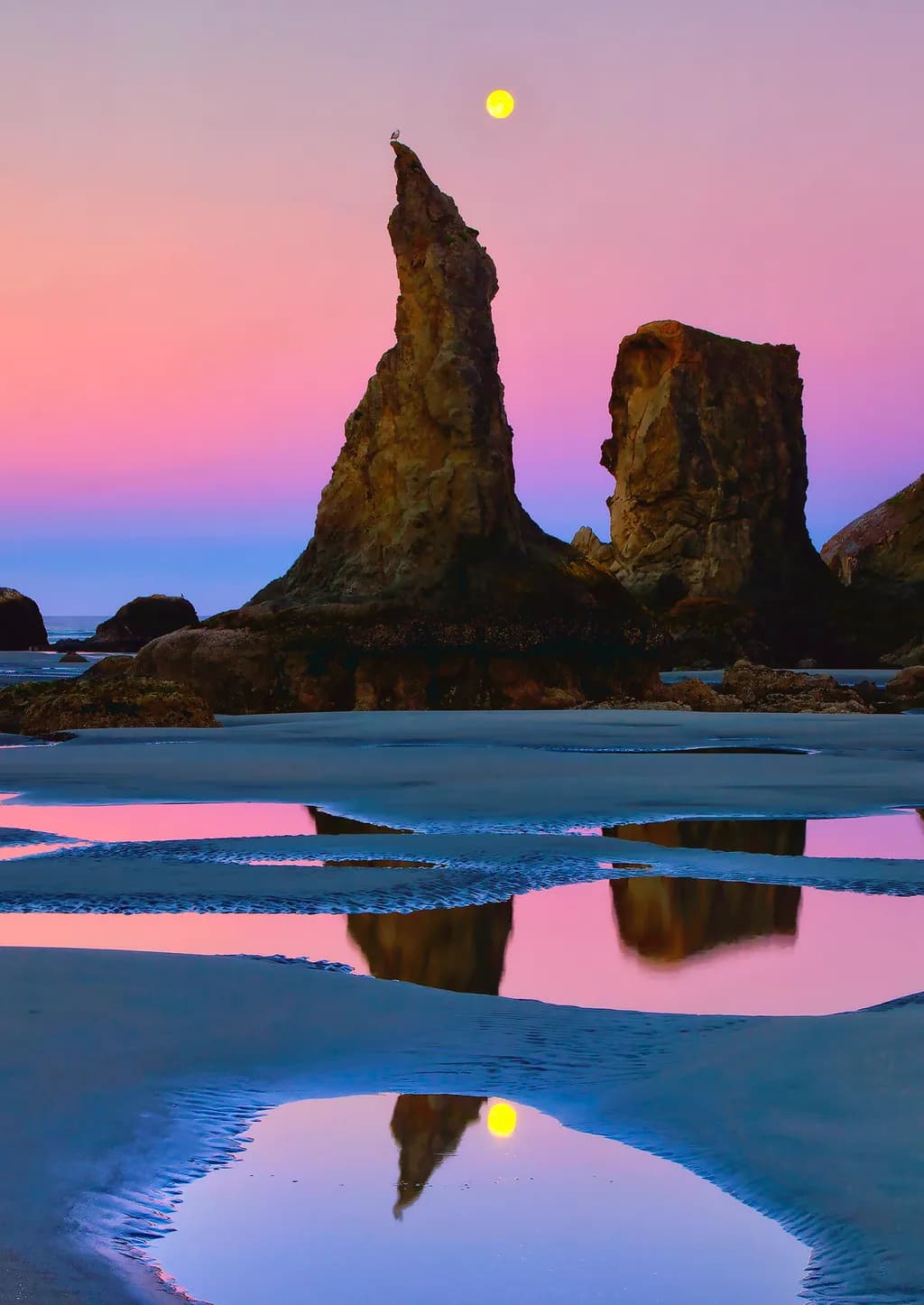 Serene Sunset Reflections: A Tranquil Beach Landscape with Moonlit Rocks