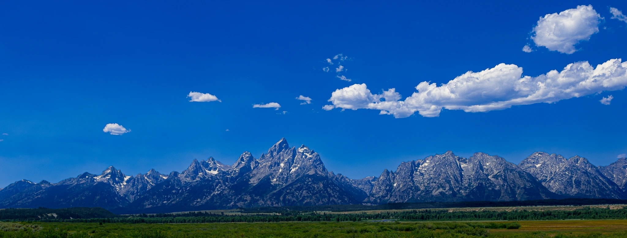 Majestic Peaks Beneath a Vast Blue Sky: A Serene Mountain Landscape Experience