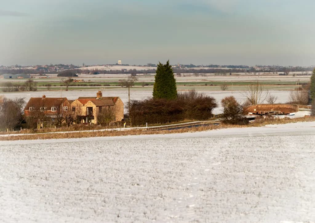 Tranquil Snowy Landscape: A Serene View of Rural Farmland