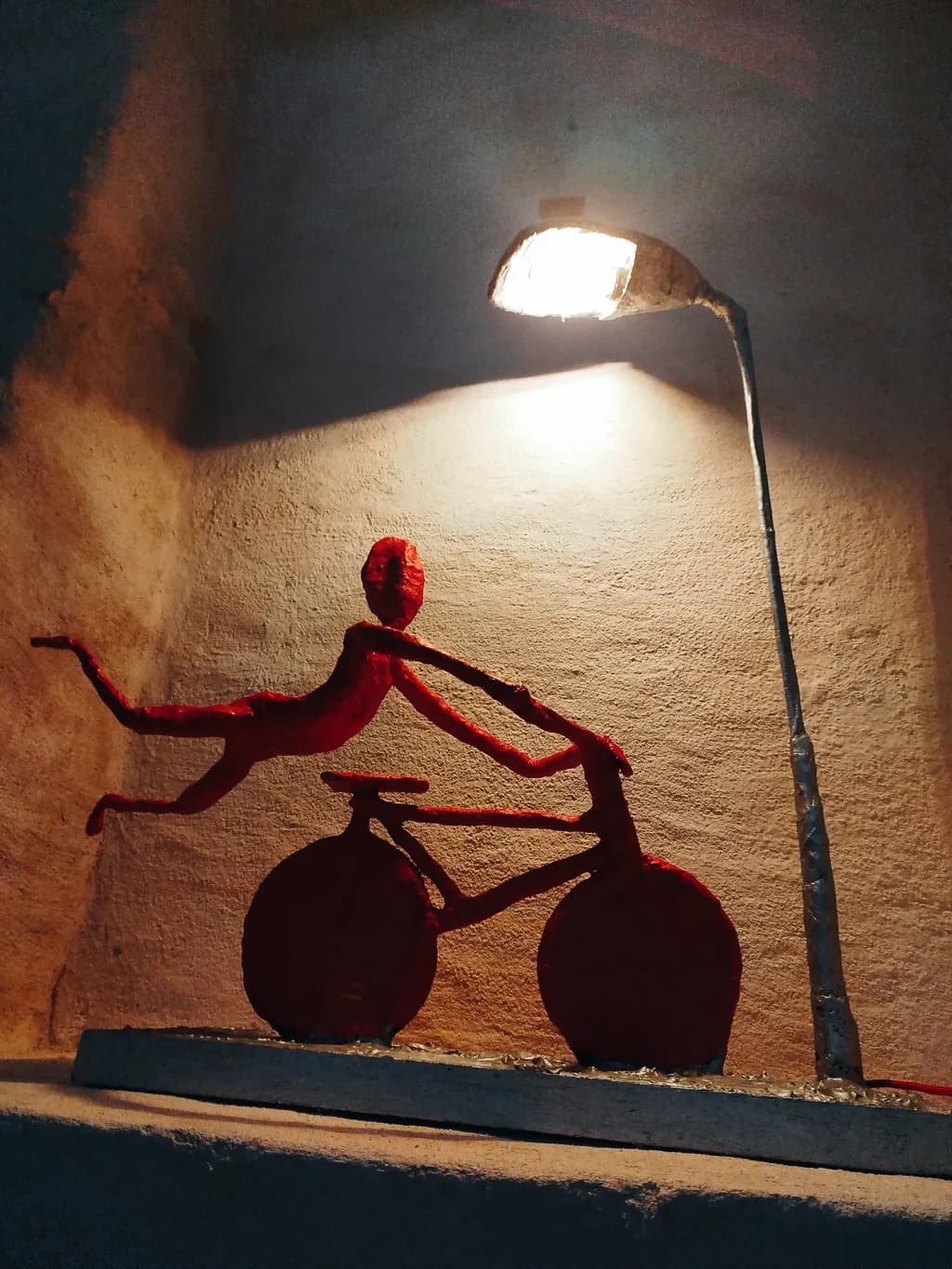 Dynamic Red Bicycle Sculpture Illuminated by Light: A Creative Artistic Expression