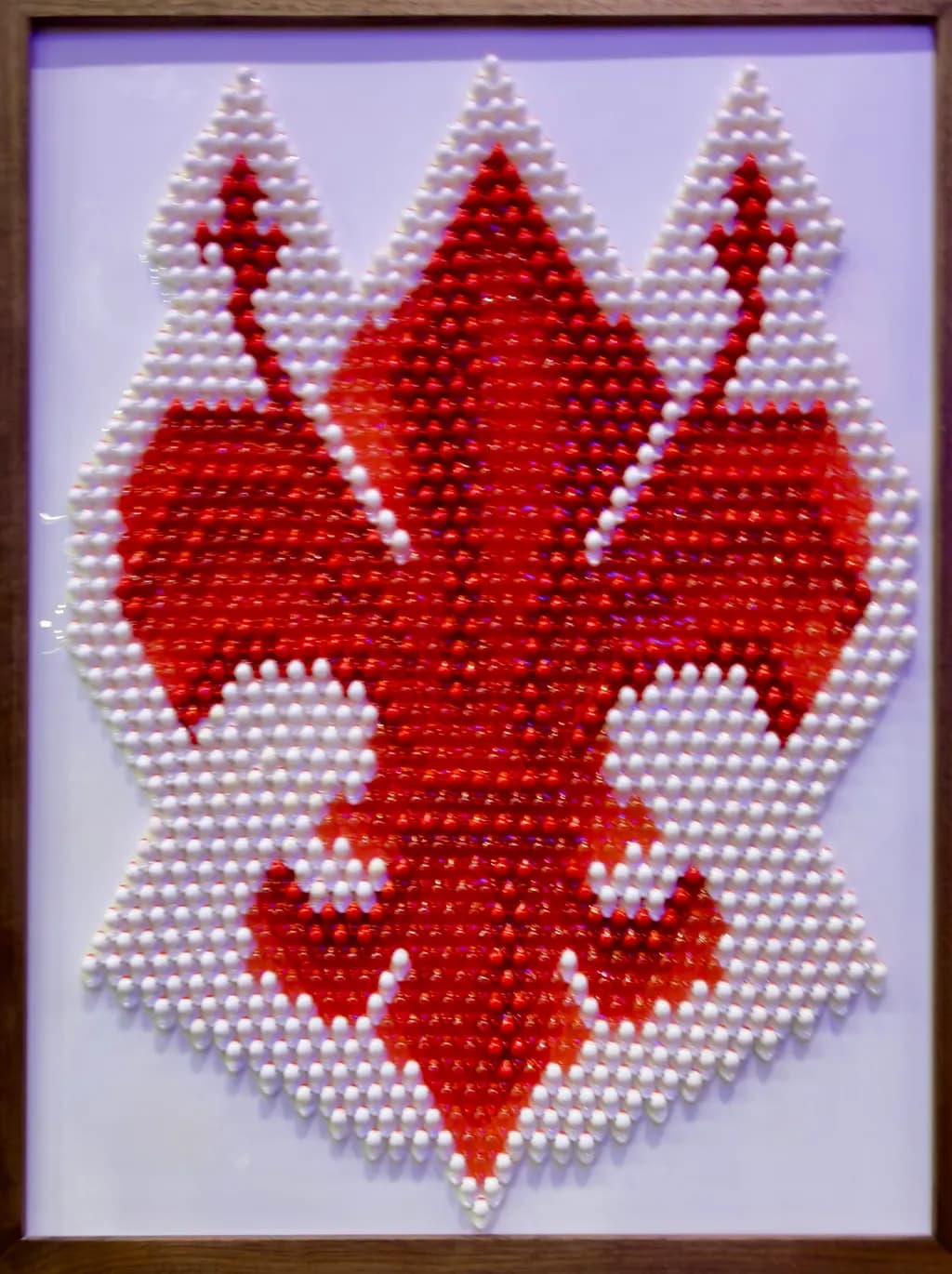 Vibrant Elegance: A Modern Interpretation of the Fleur-de-Lis in Red and White Beads
