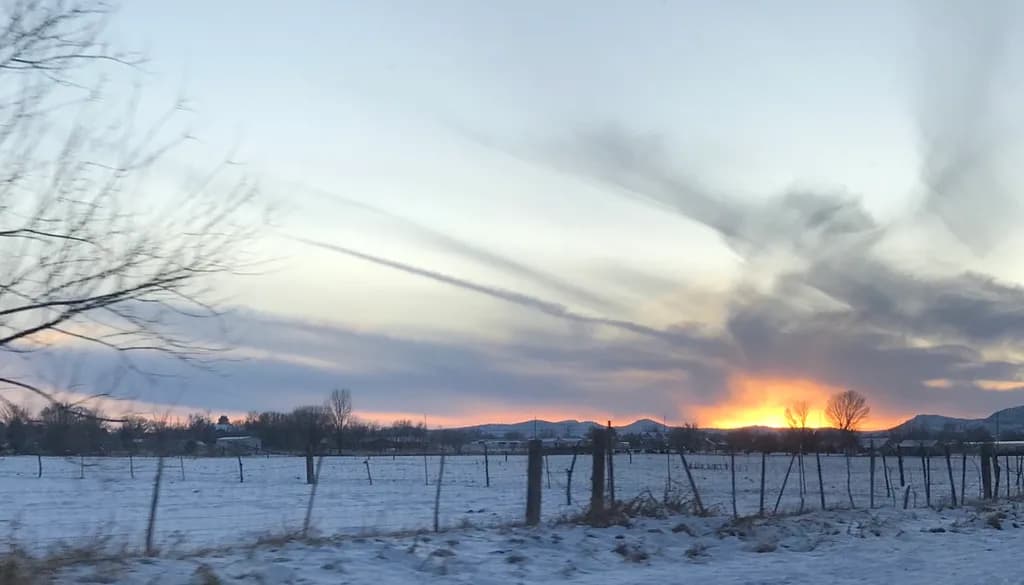Whispers of Light: A Tranquil Sunset Over Snowy Landscapes
