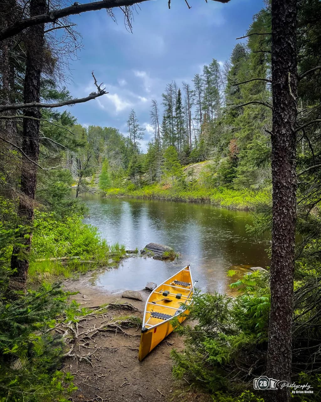 Whispers of Adventure: A Canoe's Embrace by the Tranquil Riverbank