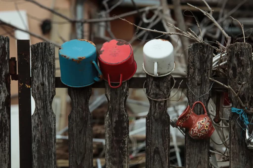Rusty Cups on Fence